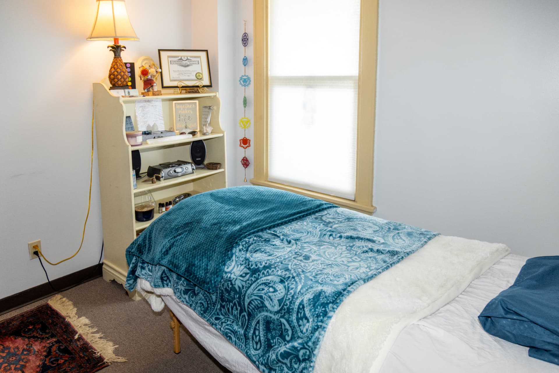 The private treatment room at Healing Better in Cincinnati, with a chakra banner and warm window light
